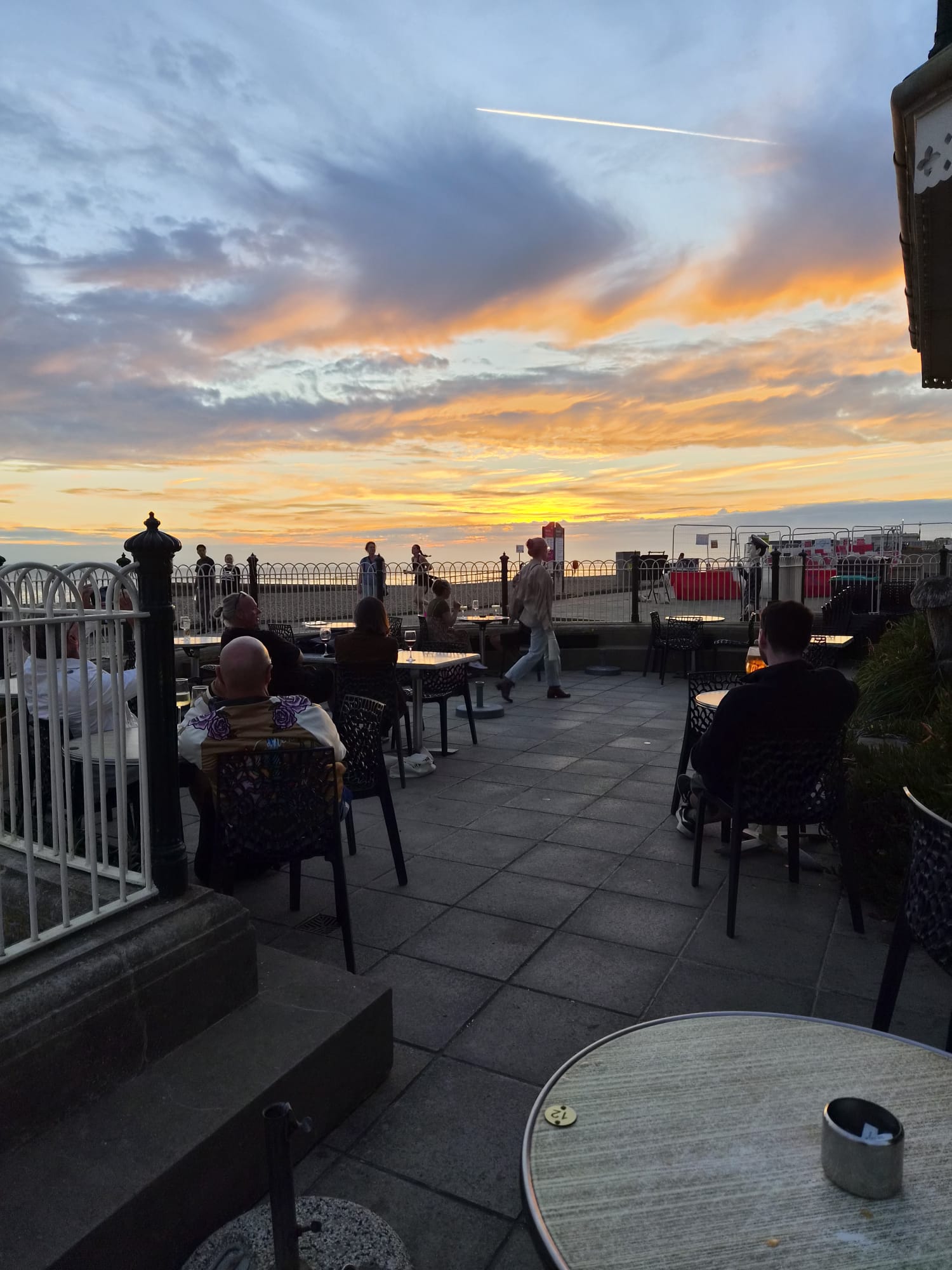 Golden sunset lighting up the tables on the seafront terrace