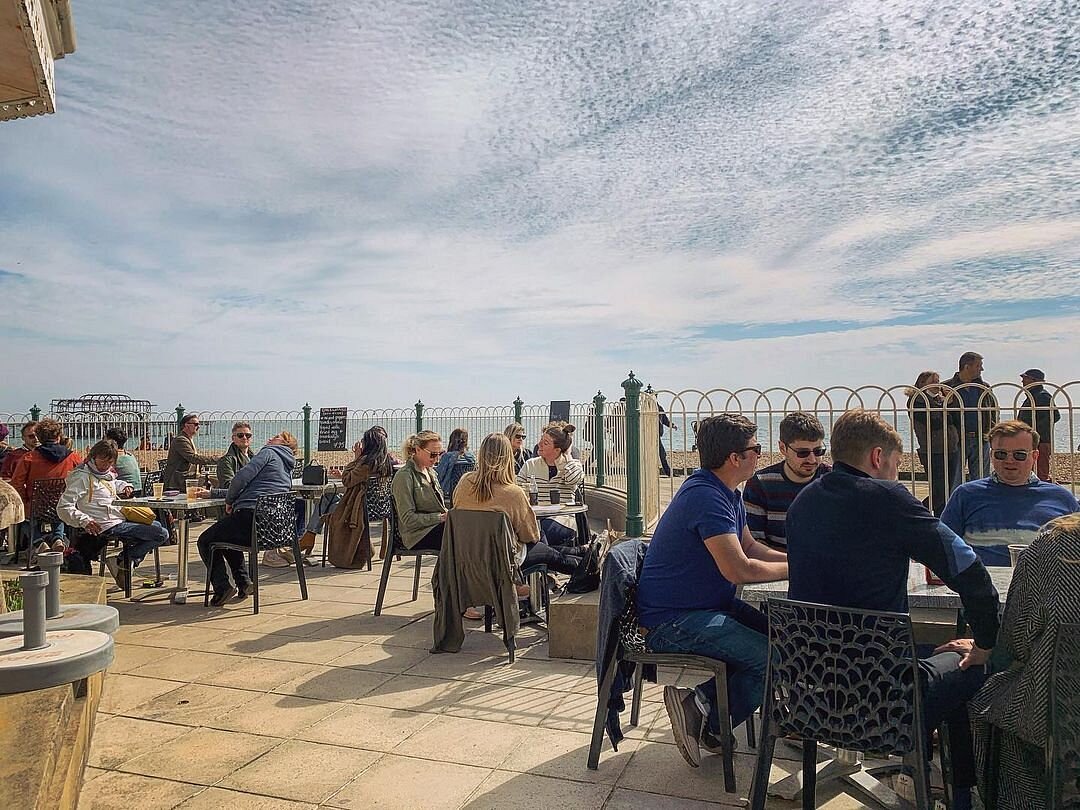 The café terrace, alive with conversation beside Brighton beach